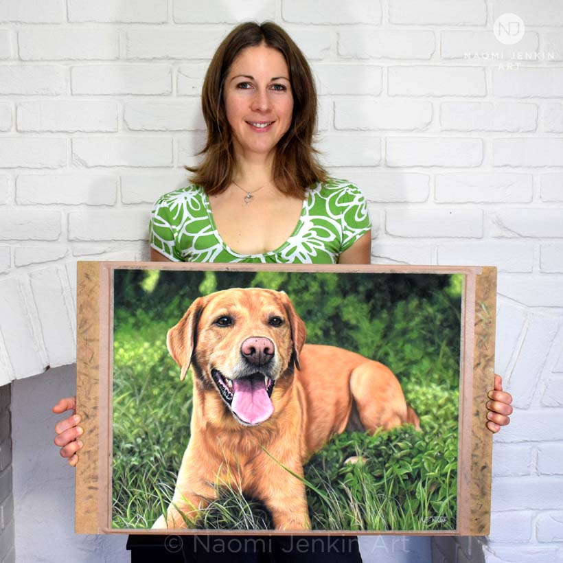 Dog portrait artist Naomi Jenkin with her Labrador portrait of Mylo.